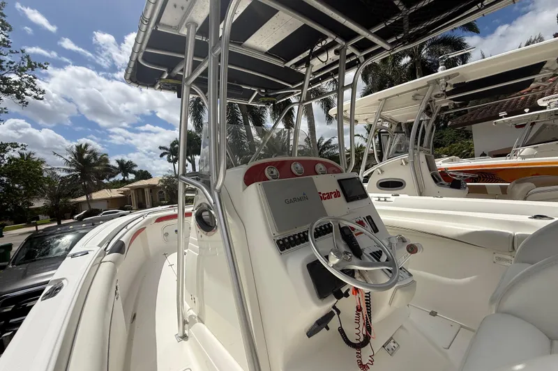Slide: The Image of 2001 Wellcraft 29 Scarab Sport Open boat with steering console, parked outdoors. - 77