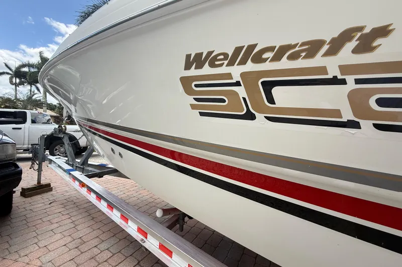 Slide: The Image of 2001 Wellcraft 29 Scarab Sport Open boat on trailer, side view with logo. - 8