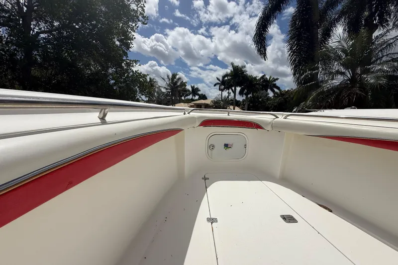 Slide: The Image of 2001 Wellcraft 29 Scarab Sport Open boat interior with red accents, under a partly cloudy sky. - 85