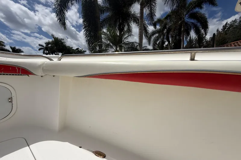 Slide: The Image of 2001 Wellcraft 29 Scarab Sport Open boat interior with palm trees and cloudy sky background. - 88