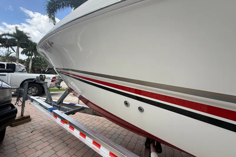 Slide: The Image of 2001 Wellcraft 29 Scarab Sport Open boat on trailer, parked outdoors. - 9
