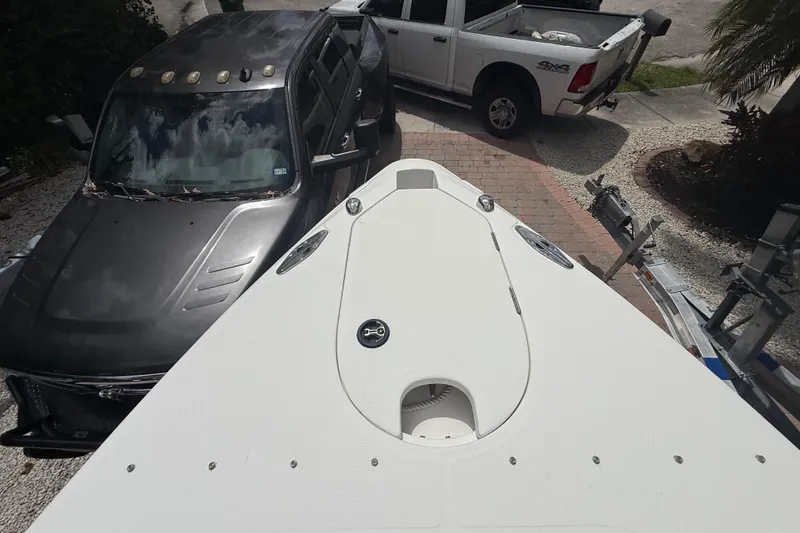 Slide: The Image of Bow view of 2001 Wellcraft 29 Scarab Sport Open, parked near two trucks. - 91