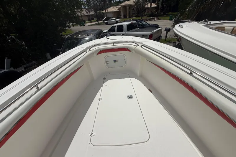 Slide: The Image of 2001 Wellcraft 29 Scarab Sport Open boat deck with red accents, parked outdoors. - 93