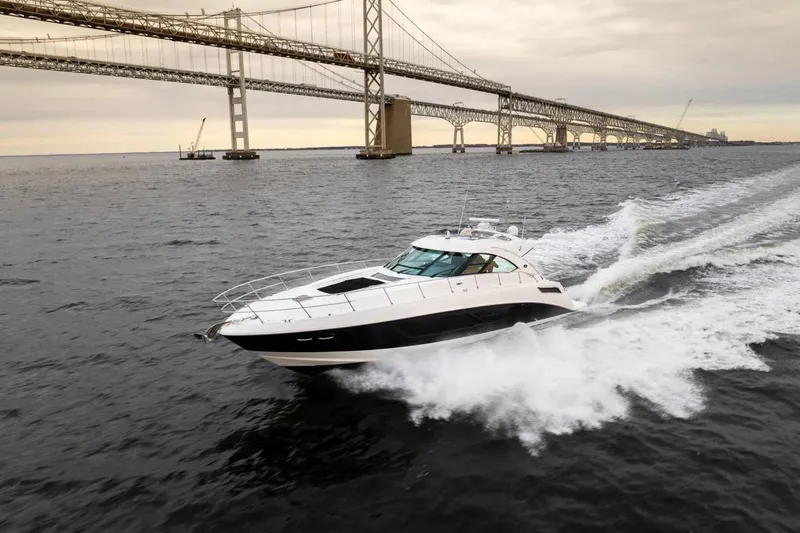 Slide: The Image of 2013 Sea Ray Sundancer 540 cruising under a large bridge on open water. - 3