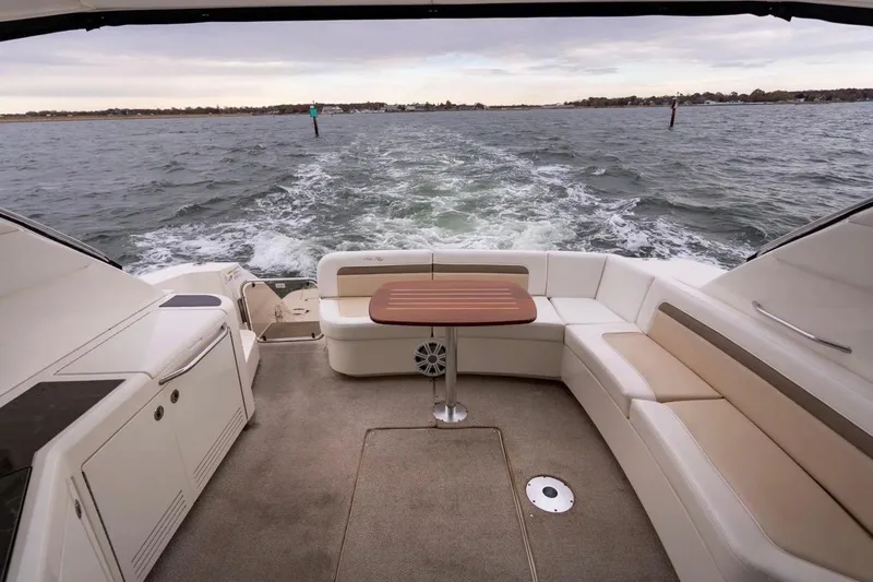 Slide: The Image of 2013 Sea Ray Sundancer 540 yacht interior with seating and table, cruising on open water. - 32