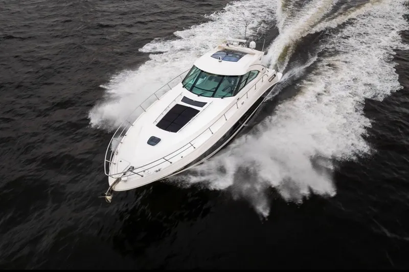 Slide: The Image of 2013 Sea Ray Sundancer 540 yacht cruising on open water, creating a dynamic wake. - 4