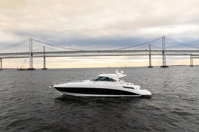 Slide: The Image of 2013 Sea Ray Sundancer 540 yacht cruising near a large suspension bridge at sunset. - 5