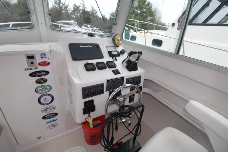 Slide: The Image of 2014 Steiger Craft 26 Miami boat cockpit with steering wheel and navigation equipment. - 11