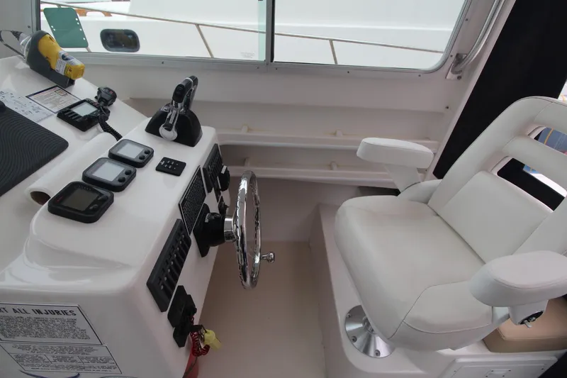 Slide: The Image of 2014 Steiger Craft 26 Miami boat helm with steering wheel and control panel. - 12