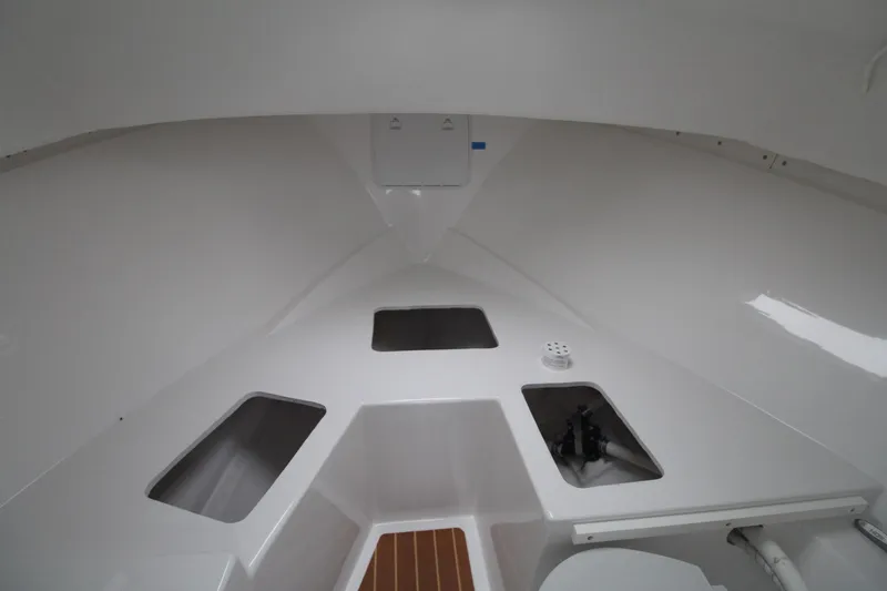 Slide: The Image of Interior of a 2014 Steiger Craft 26 Miami boat, featuring storage compartments. - 16