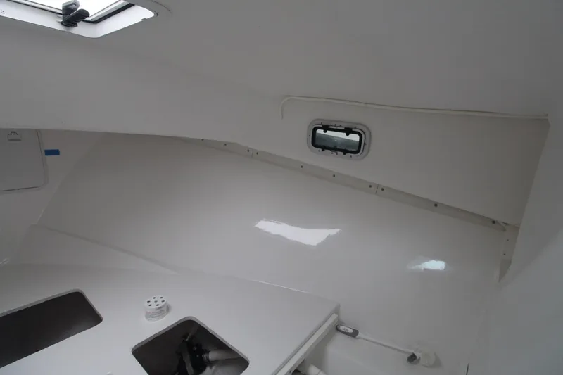 Slide: The Image of Interior cabin of 2014 Steiger Craft 26 Miami boat, featuring sleek white design. - 20