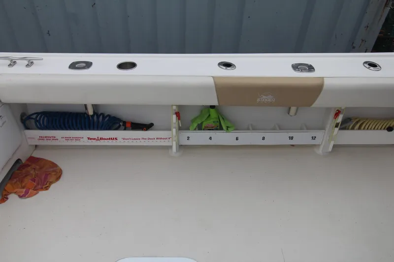 Slide: The Image of 2014 Steiger Craft 26 Miami boat deck with storage compartments and coiled hoses. - 23
