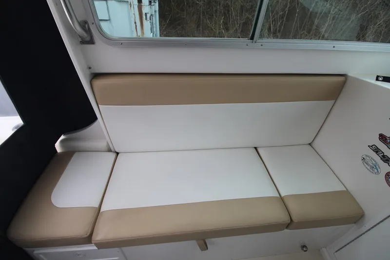 Slide: The Image of 2014 Steiger Craft 26 Miami boat interior with beige and white cushioned seating. - 7