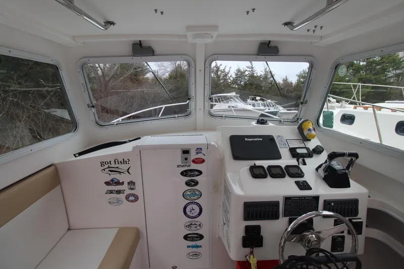 Slide: The Image of 2014 Steiger Craft 26 Miami boat interior with control panel and seating area. - 9