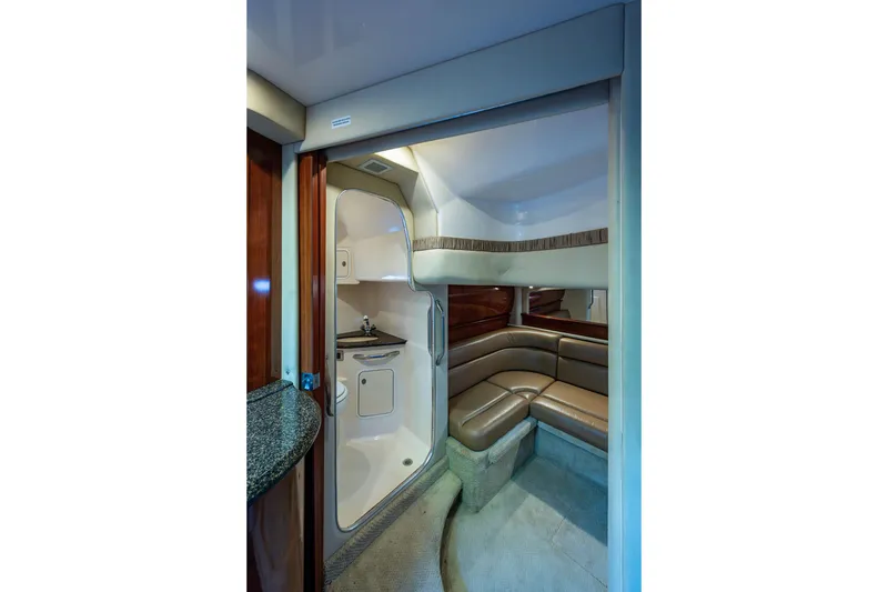 Slide: The Image of Interior of 2005 Sea Ray 420 Sundancer yacht, featuring a cozy seating area and compact bathroom. - 17