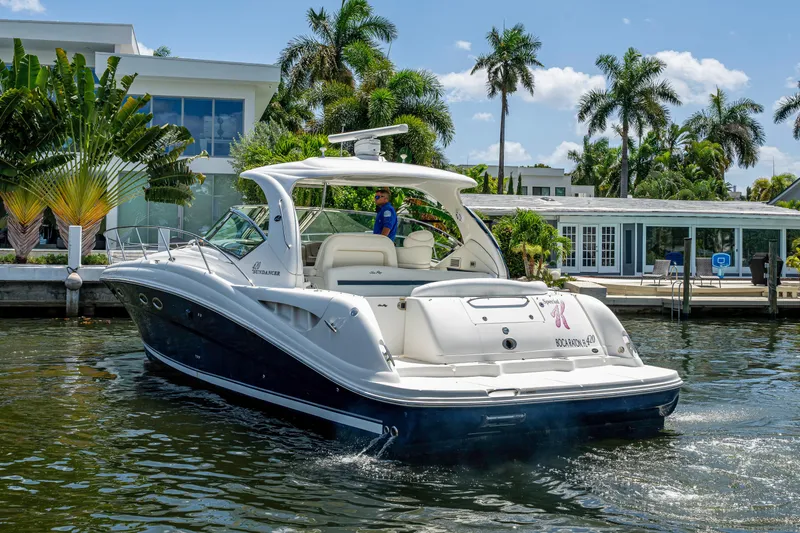 Slide: The Image of 2005 Sea Ray 420 Sundancer yacht cruising near waterfront homes with palm trees. - 4