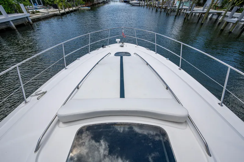 Slide: The Image of 2005 Sea Ray 420 Sundancer yacht bow view, cruising through a serene waterway. - 5