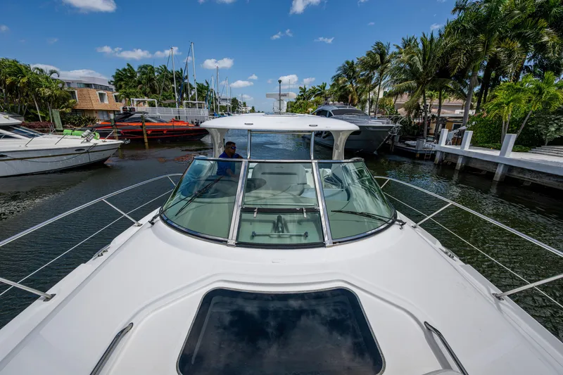 Slide: The Image of 2005 Sea Ray 420 Sundancer cruising in a scenic canal with palm trees and boats. - 6