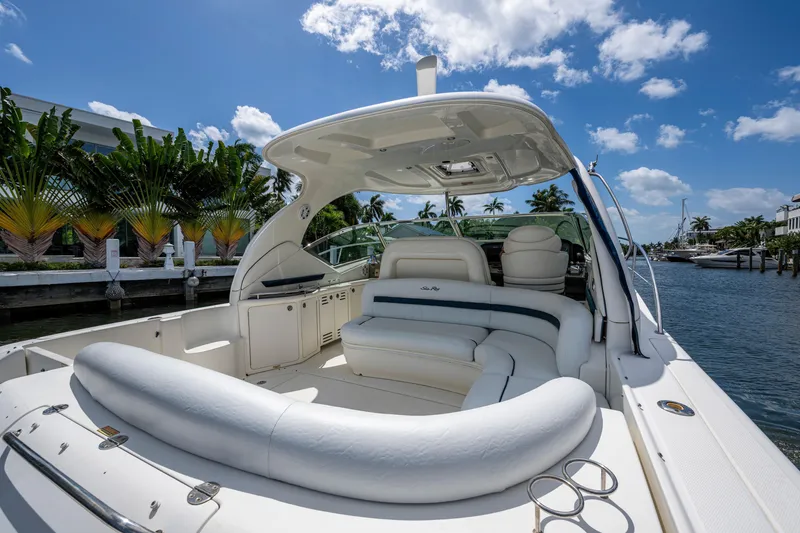 Slide: The Image of 2005 Sea Ray 420 Sundancer yacht with luxurious seating, docked by tropical waterfront. - 9