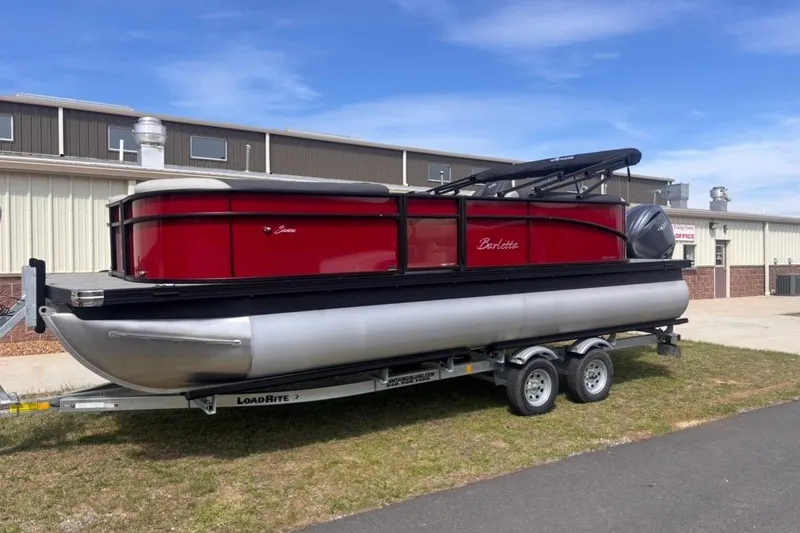 The Image of 2026 Barletta Sanza S22QC pontoon boat on trailer, parked outside industrial building. - 1