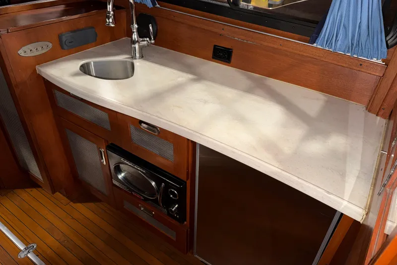 Slide: The Image of 1986 Skiff Craft X-31 Sportsman Custom boat interior with sink, countertop, and appliances. - 12