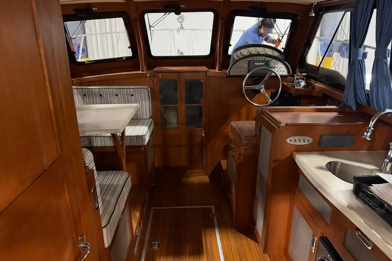 Slide: The Image of 1986 Skiff Craft X-31 Sportsman Custom interior with wood finish, dining area, and steering wheel. - 16