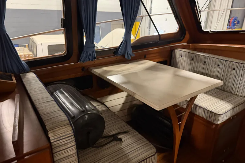 Slide: The Image of Interior of 1986 Skiff Craft X-31 Sportsman Custom with striped seating and wooden table. - 17