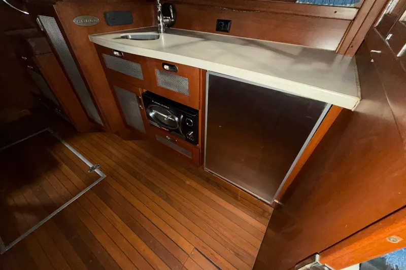 Slide: The Image of 1986 Skiff Craft X-31 Sportsman Custom boat interior with wooden flooring and kitchenette. - 24