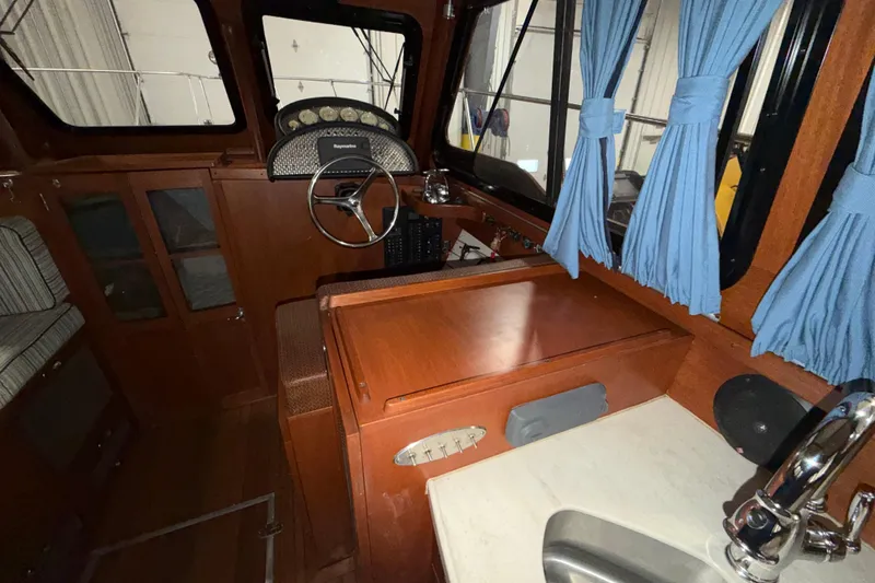 Slide: The Image of 1986 Skiff Craft X-31 Sportsman Custom boat interior with wood finish and blue curtains. - 26