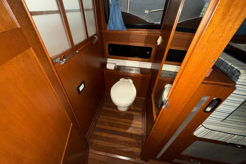 Slide: The Image of 1986 Skiff Craft X-31 Sportsman Custom boat interior with wooden bathroom and toilet. - 32