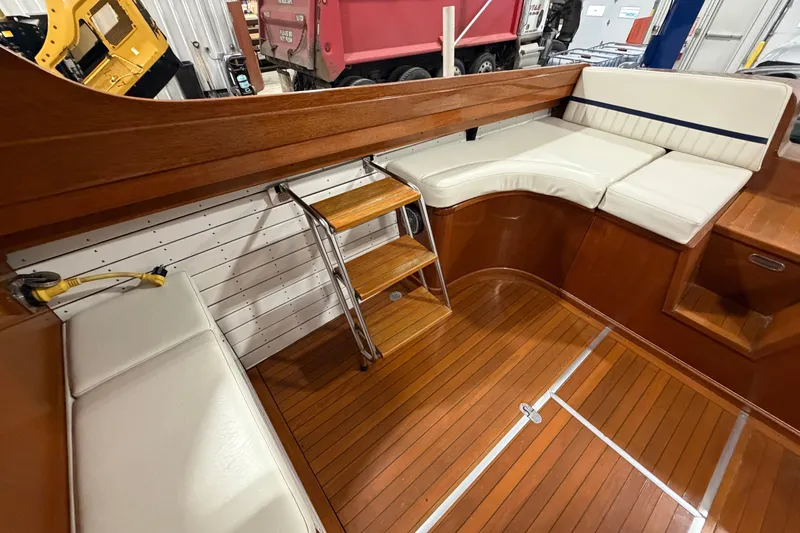 Slide: The Image of 1986 Skiff Craft X-31 Sportsman Custom interior with wooden flooring and white seating. - 4