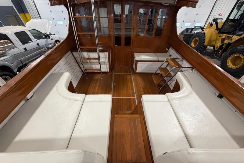 Slide: The Image of 1986 Skiff Craft X-31 Sportsman Custom boat interior with wooden and white seating. - 5