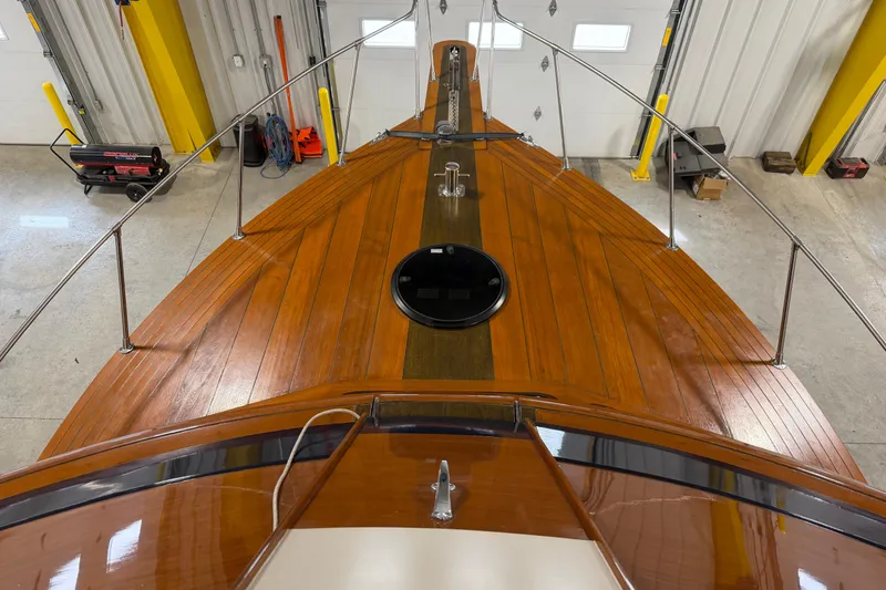 Slide: The Image of 1986 Skiff Craft X-31 Sportsman Custom boat with polished wooden deck in a garage. - 7