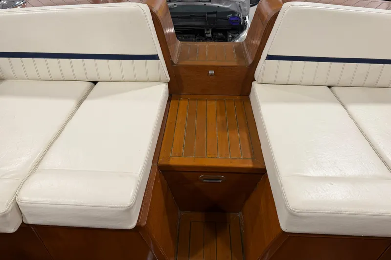 Slide: The Image of 1986 Skiff Craft X-31 Sportsman Custom boat interior with white cushioned seating and wooden accents. - 9