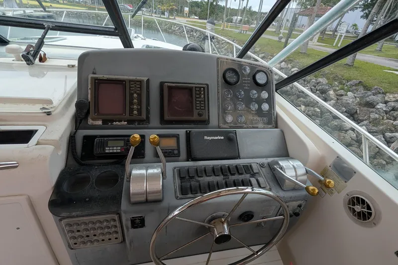 Slide: The Image of 1998 Tiara Yachts 4100 Open helm with navigation controls and steering wheel. - 12