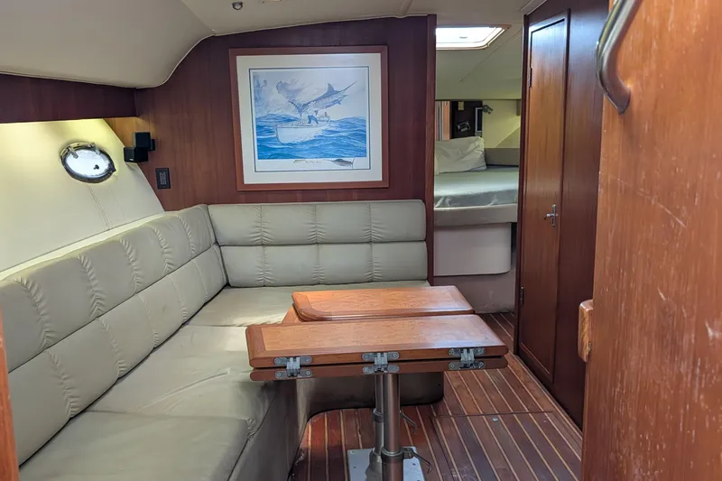 Slide: The Image of Interior of a 1998 Tiara Yachts 4100 Open with beige seating and wooden table. - 14