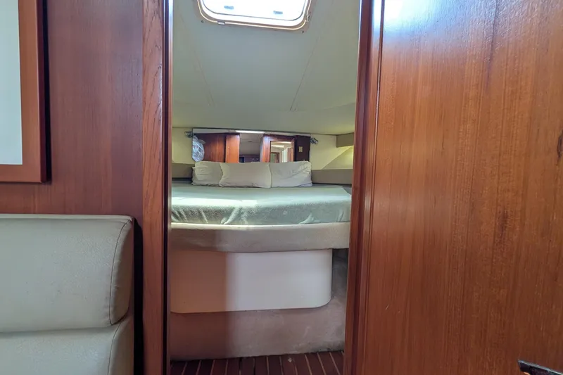 Slide: The Image of Interior cabin of 1998 Tiara Yachts 4100 Open, featuring a cozy bed and wooden finish. - 19