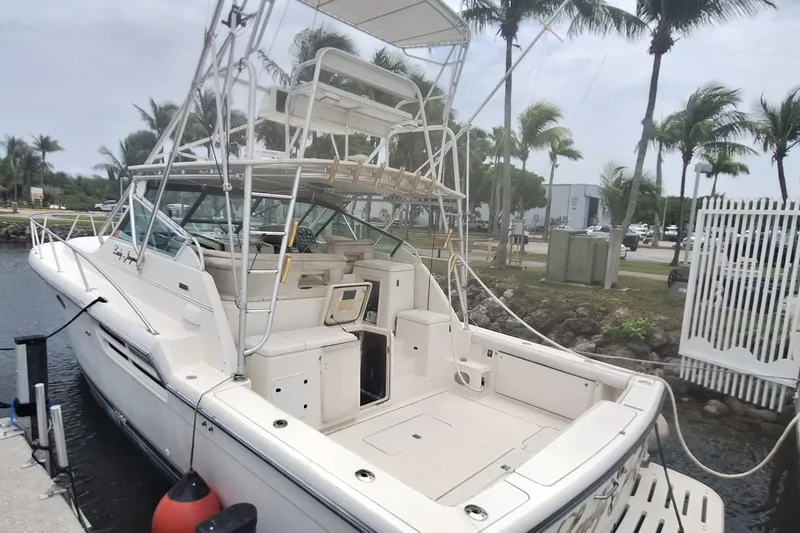 Slide: The Image of 1998 Tiara Yachts 4100 Open docked with palm trees in the background. - 2