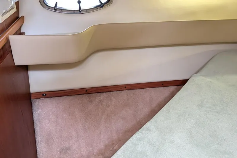 Slide: The Image of Interior cabin of 1998 Tiara Yachts 4100 Open, featuring a cozy bed and porthole window. - 22