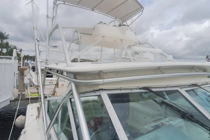 Slide: The Image of 1998 Tiara Yachts 4100 Open docked, showcasing helm and upper deck structure. - 4