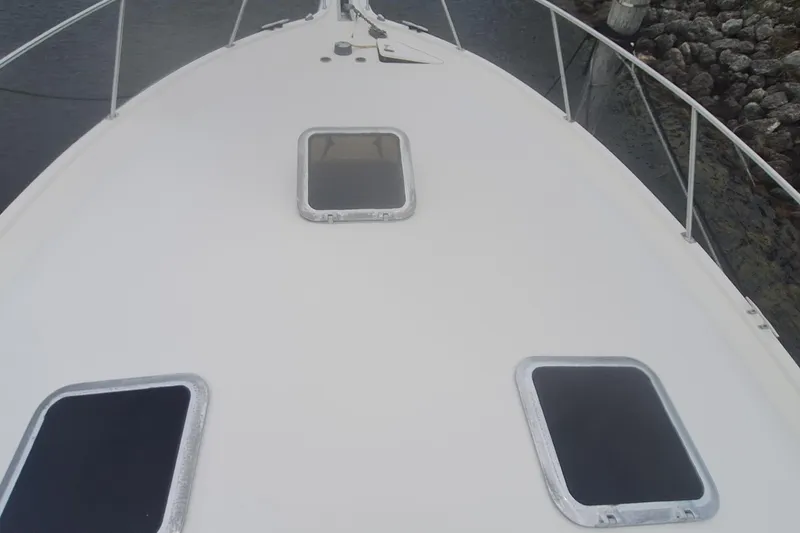 Slide: The Image of Bow view of a 1998 Tiara Yachts 4100 Open, featuring deck hatches and railings. - 5