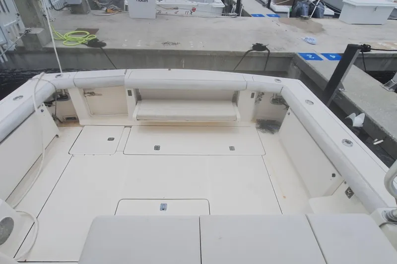 Slide: The Image of 1998 Tiara Yachts 4100 Open boat deck at marina, featuring spacious seating and storage. - 9