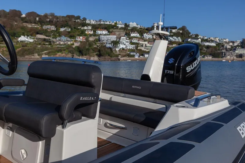 Slide: The Image of 2026 Brig Eagle 6.7 boat with Suzuki engine, docked near scenic coastal town. - 7