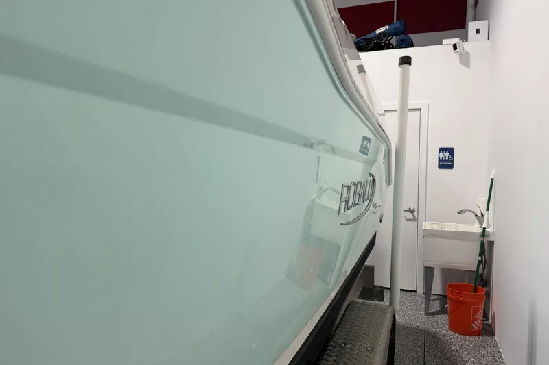 Slide: The Image of 2021 Robalo R200 Center Console boat in indoor storage near restroom sign. - 17