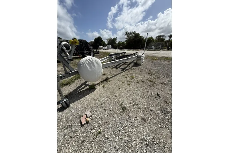 Slide: The Image of Trailer for 2021 Robalo R200 Center Console boat on gravel lot under blue sky. - 22
