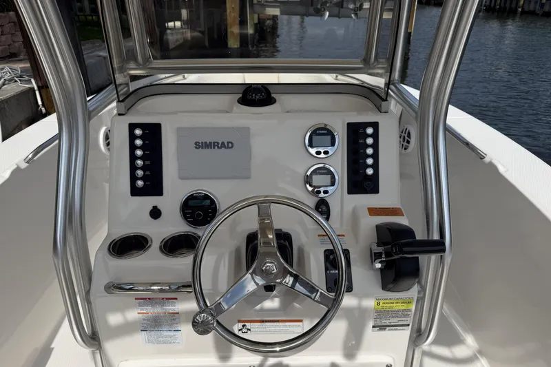 Slide: The Image of 2021 Robalo R200 Center Console boat dashboard with steering wheel and Simrad display. - 7