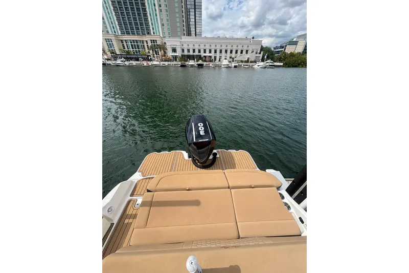 Slide: The Image of 2019 Sea Ray SDX 270 Outboard boat with tan seating, docked near waterfront buildings. - 10