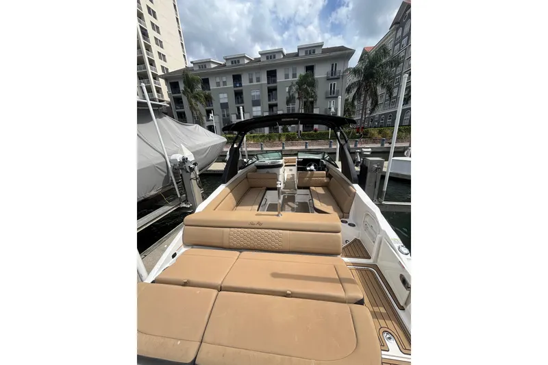 Slide: The Image of 2019 Sea Ray SDX 270 Outboard boat with tan seating, docked near waterfront buildings. - 11