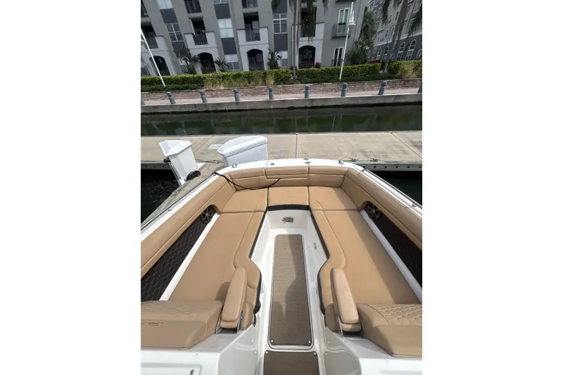 Slide: The Image of 2019 Sea Ray SDX 270 Outboard boat with tan seating, docked near waterfront buildings. - 4