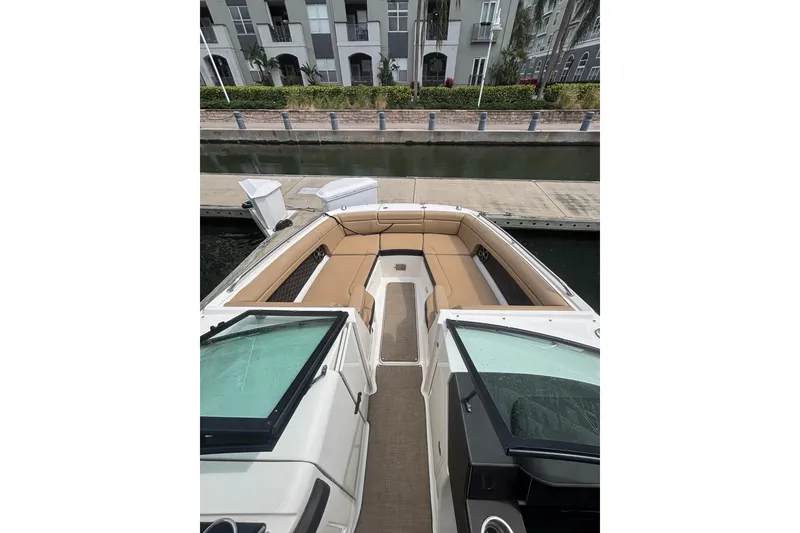 Slide: The Image of 2019 Sea Ray SDX 270 Outboard boat with tan seating, docked near waterfront buildings. - 6